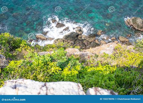 Looking Over A Cliff Edge With Blue Sea Below And Cliff Edge And The