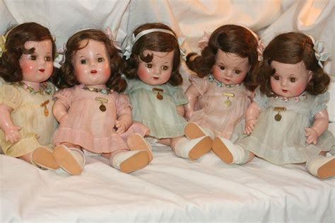 Five Porcelain Dolls Are Sitting On A White Sheet