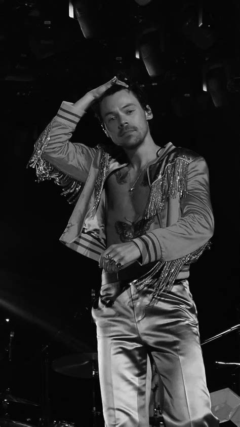 A Shirtless Man Standing On Stage With His Hands In His Hair