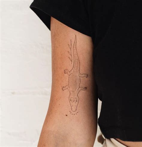 A Woman S Arm With A Tattoo Of A Bird On The Back Of It