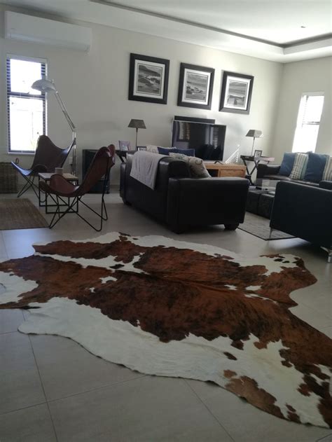 A Living Room Filled With Furniture And A Cowhide Rug On The Floor In