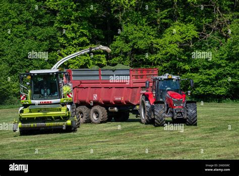 Tractor With Trailer Running Beside Claas Jaguar Forage Harvester