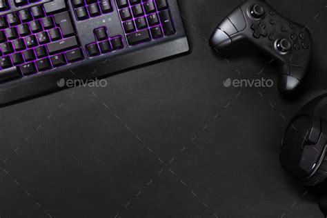 Purple lit keyboard by game controller and mouse Stock Photo by kjekol