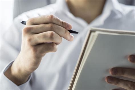 Premium Photo Man Writes Standing With A Pen In Notepad In A Sunny