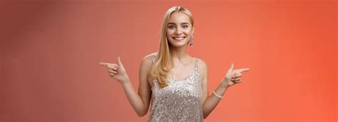 Tourné à la taille gaie fille européenne blonde sous tension en robe scintillante argentée