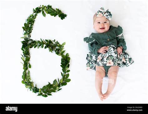 6 month old baby girl in a green dress. Baby milestone six months Stock ...