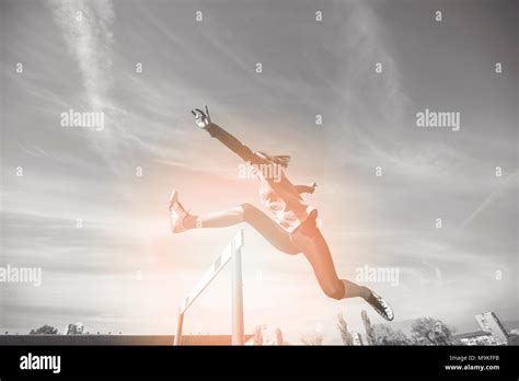 Female Athlete Jumping Above The Hurdle During The Race Stock Photo Alamy