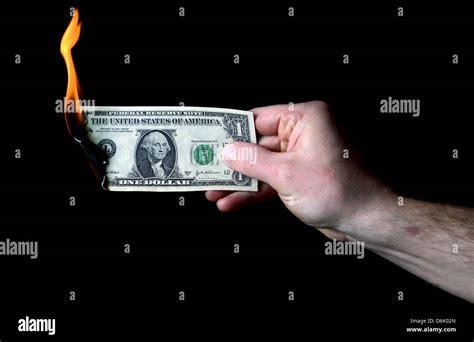 Hand Holding Burning Dollar Isolated On Black Concept Of Money To Burn