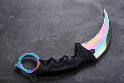 A dagger with a steel blade with a gradient color on a black background ...