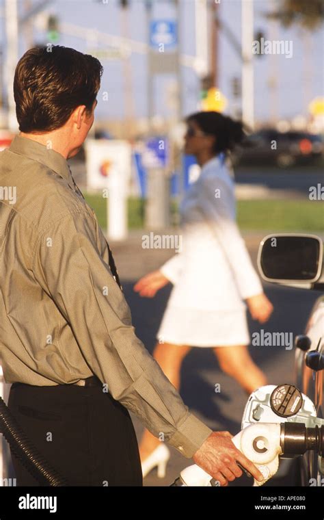 Man at gas pump in California self serve gas station watching passing woman Stock Photo - Alamy