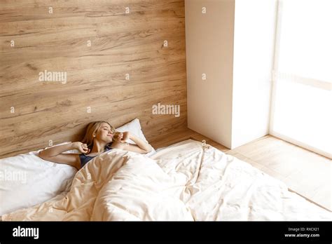 Young Beautiful Blonde Woman Lying In Bed In Morning She Wakes Up Model Stretch Hands Up