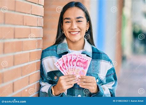 Joven Latina Sonriendo Feliz Sosteniendo Billetes De Yuanes Chinos En