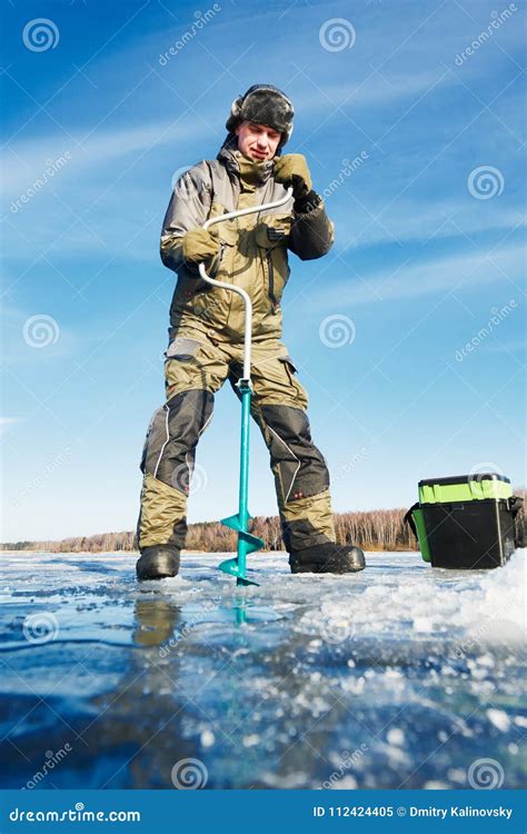 Pescador O Eixo Helicoidal Na Pesca Do Gelo Do Inverno Imagem De