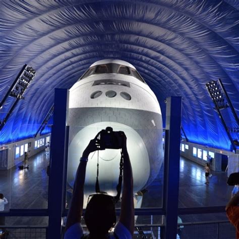 people are taking pictures of the space shuttle on display in a museum ...