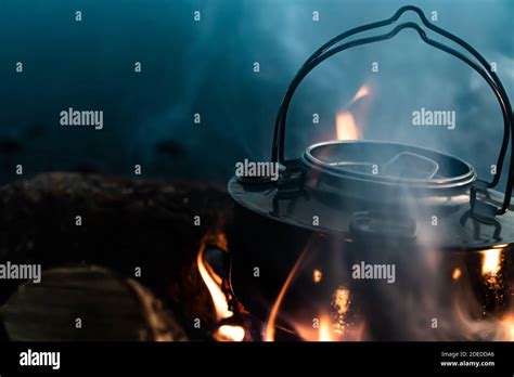 Steel Kettle Boiling Water On The Flames Of A Camp Fire Close Up