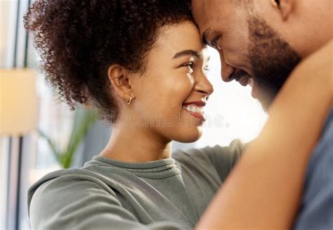 Happy Mixed Race Couple Hugging While Relaxing At Home Carefree