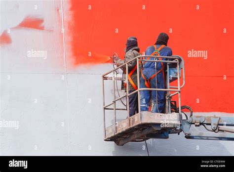 Spray painting ship in dry dock Stock Photo - Alamy