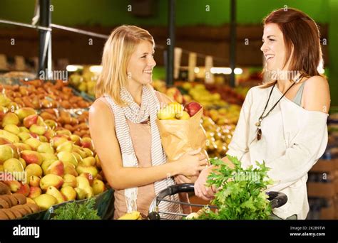 Sharing A Laugh At The Grocery Store Two Attractive Women Shopping For