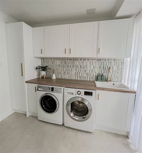 A Washer And Dryer Sitting In A Kitchen Next To Each Other On Top Of A