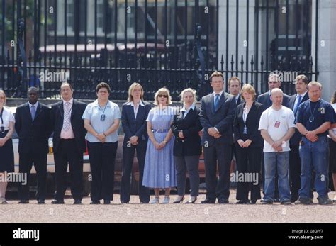 Buckingham palace staff stand silently in the london palace forecourt ...