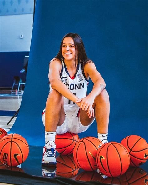 A Woman Sitting On Top Of Basketball Balls