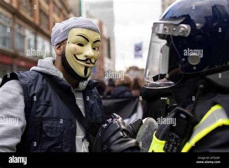 Protester in Guy Fawkes mask talks with riot police officer, 'Free ...