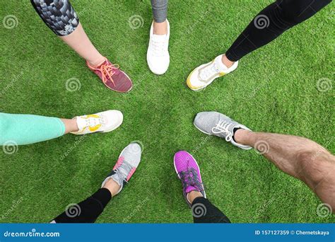 Closeup Of Athletes Wearing Sports Shoes And Standing In Circle On