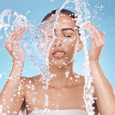 Woman Hands Or Washing Face In Water Splash On Blue Background Studio