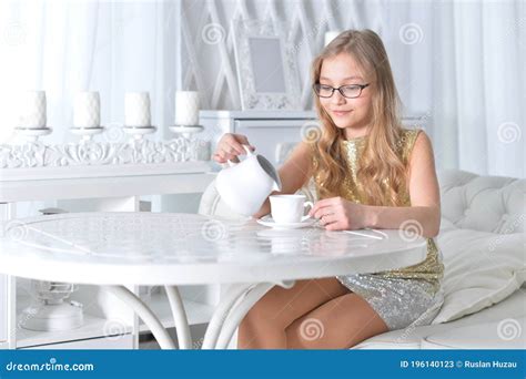 Teen Girl In Eyeglasses Sitting At White Table And Drinking Tea Stock Image Image Of