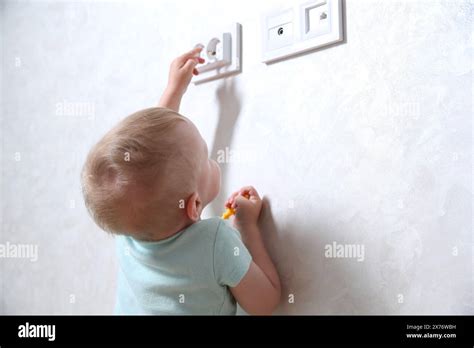 Little Child Playing With Electrical Socket Indoors Dangerous