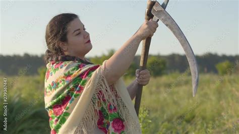 Vid O Stock Portrait Of Beautiful Overweight Woman Sharpening Scythe