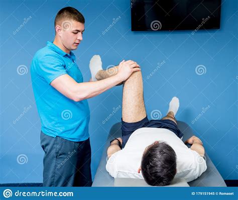 Rehabilitation Therapy Physiotherapist Working With Young Male Patient