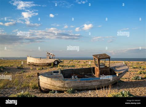 Abandoned Fishing Boat On Shingle Beach Landscape At Sunset Stock Photo