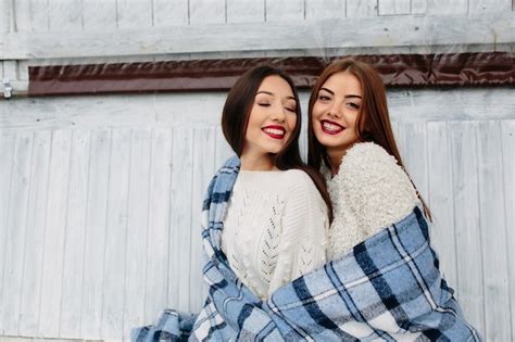 Dos Mujeres Se Sientan En Un Banco En El Parque Y Posando Foto Gratis