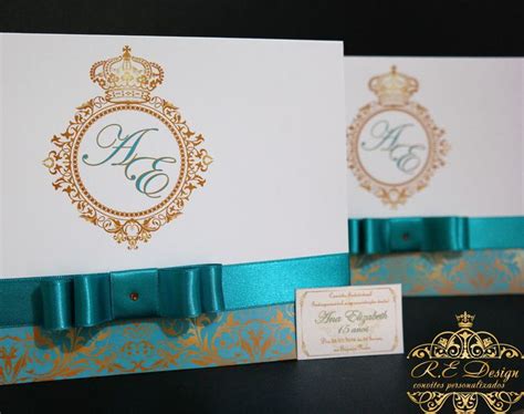 Two Wedding Cards With Gold And Teal Details On Them Sitting Next To