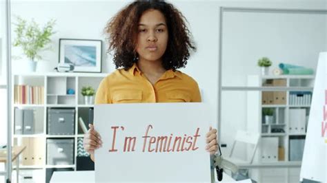 Slow Motion Of Serious African American Lady Standing With I M Feminist Poster Indoors Stock