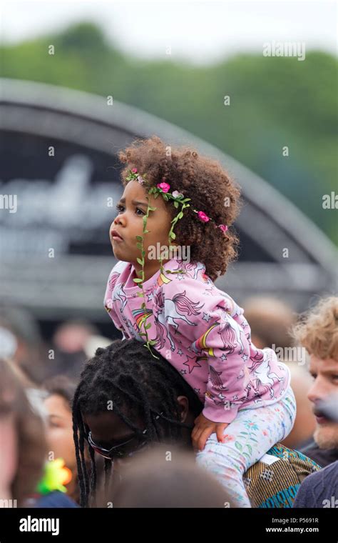 Gorgeous mixed race baby girl sitting on an adult's shoulders at the ...