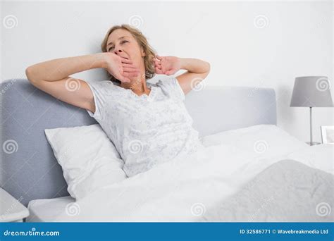 Blonde Woman Yawning And Stretching In Bed In The Morning Stock Image