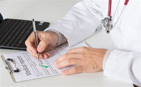 Premium Photo Midsection Of Doctor Writing On Medical Record