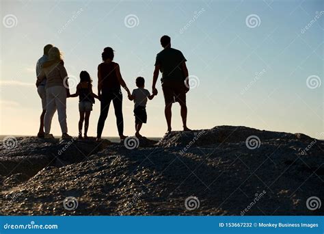 Famille De Trois Générations Sur Une Plage Tenant Des Mains Admirant