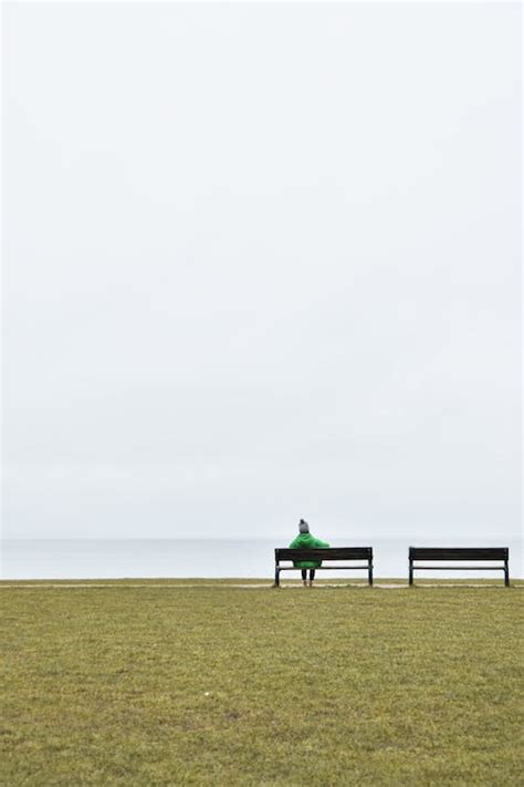 A Person Sitting alone on a Bench on the Seashore · Free Stock Photo