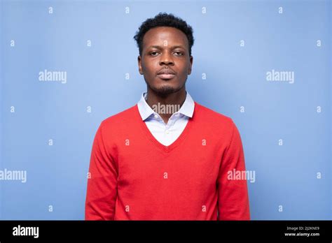 Serious African American Millennial Man In Red Sweater Isolated On Blue