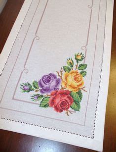 An Embroidered Table Runner With Flowers On It