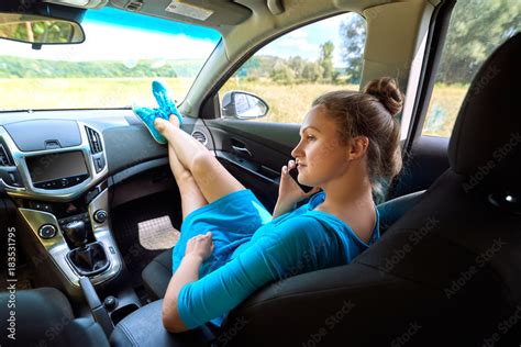 Girl In Car Sitting On Passenger Seat With Feet On Car Dashboard And