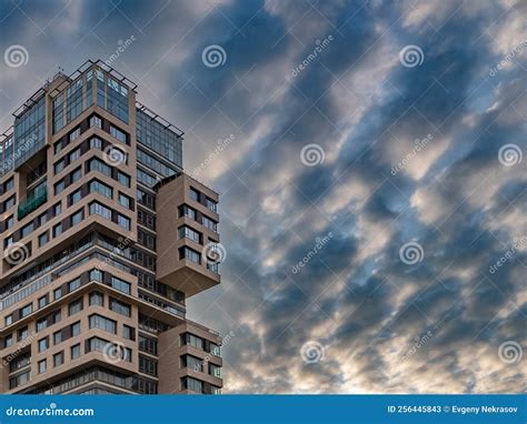 A Modern High Rise Building Against A Dramatic Sky With Clouds Stock