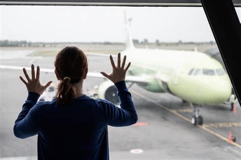 Premium Photo Rear View Of Woman Looking At Airplane Through Glass