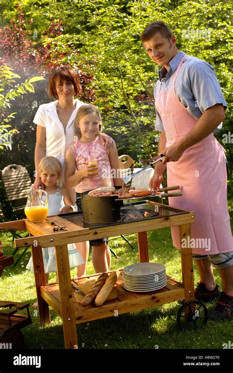 Family having a barbecue in the garden Stock Photo - Alamy