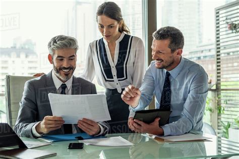 Smiling business people working in office - Stock Photo - Dissolve