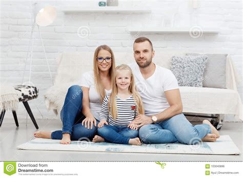 Famille Heureuse à La Maison S asseyant Sur Le Plancher Photo stock