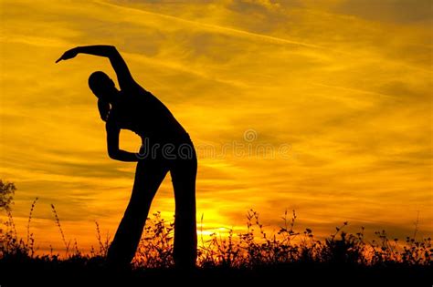 Silhouette Of A Slim Girl Standing On A Beach With Setting Sun She